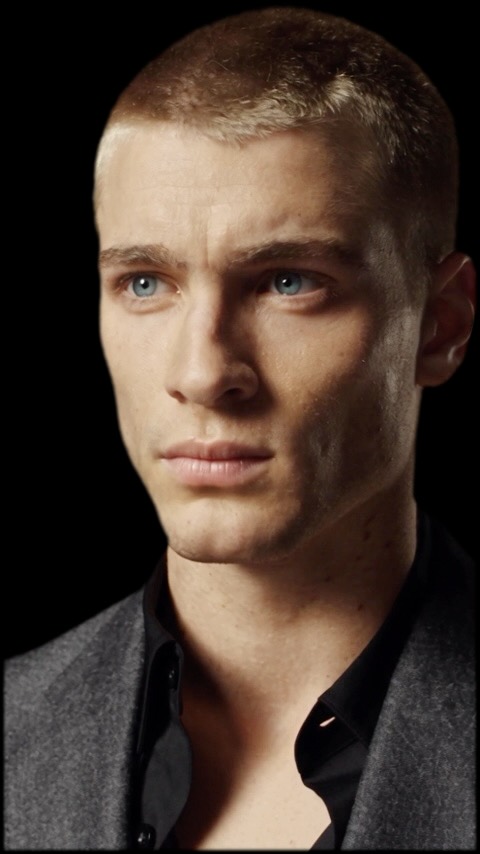 A man's face, almost entirely in shadow